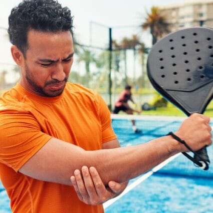 Man holding his sore elbow during pickleball.