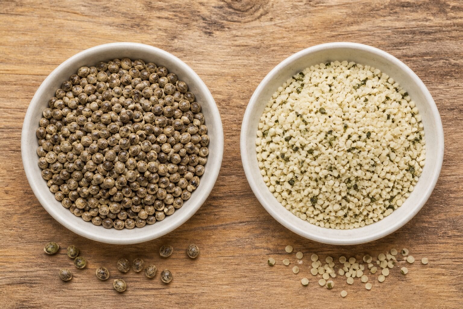 Whole hemp seeds beside pale hulled hemp hearts